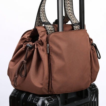 Sac de voyage glissé sur une valise cabine